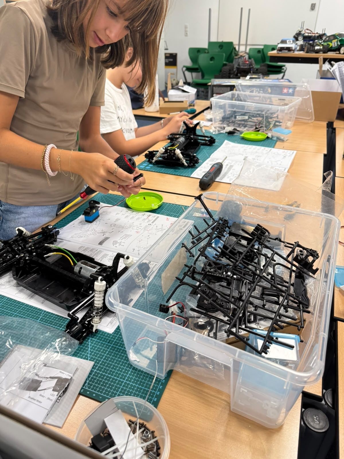 Girls assembling Tamiya RC car chassis kits at RC Garage Summer Camp Vienna