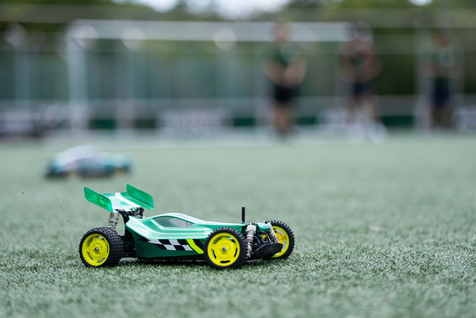 Green Tamiya buggy driving across grass at an RC Garage driving day in Vienna
