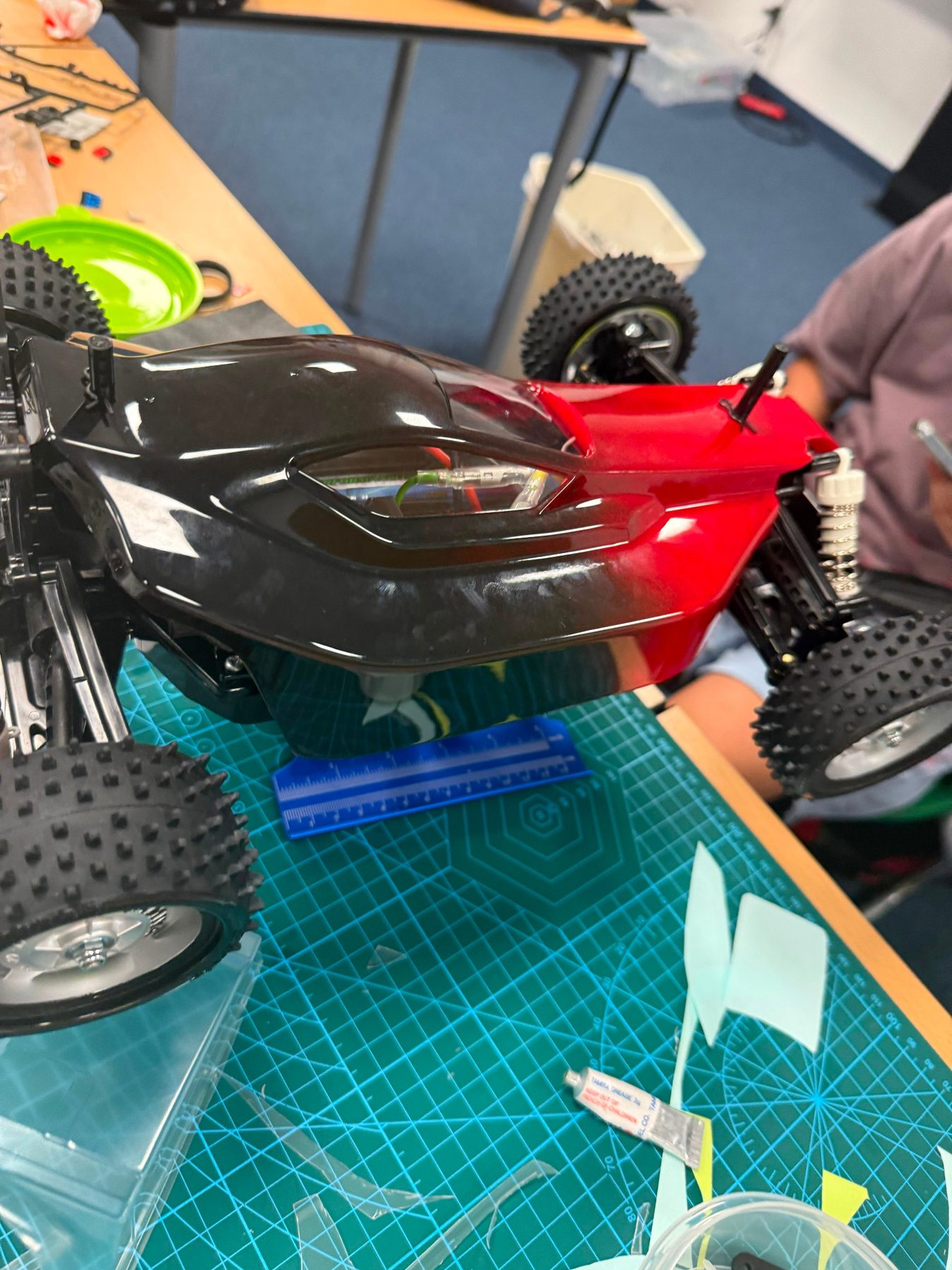 Custom painted black and red RC buggy body being fitted at RC Garage Summer Camp
